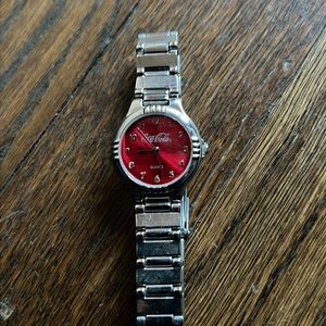 Coca Cola silver watch with red face.